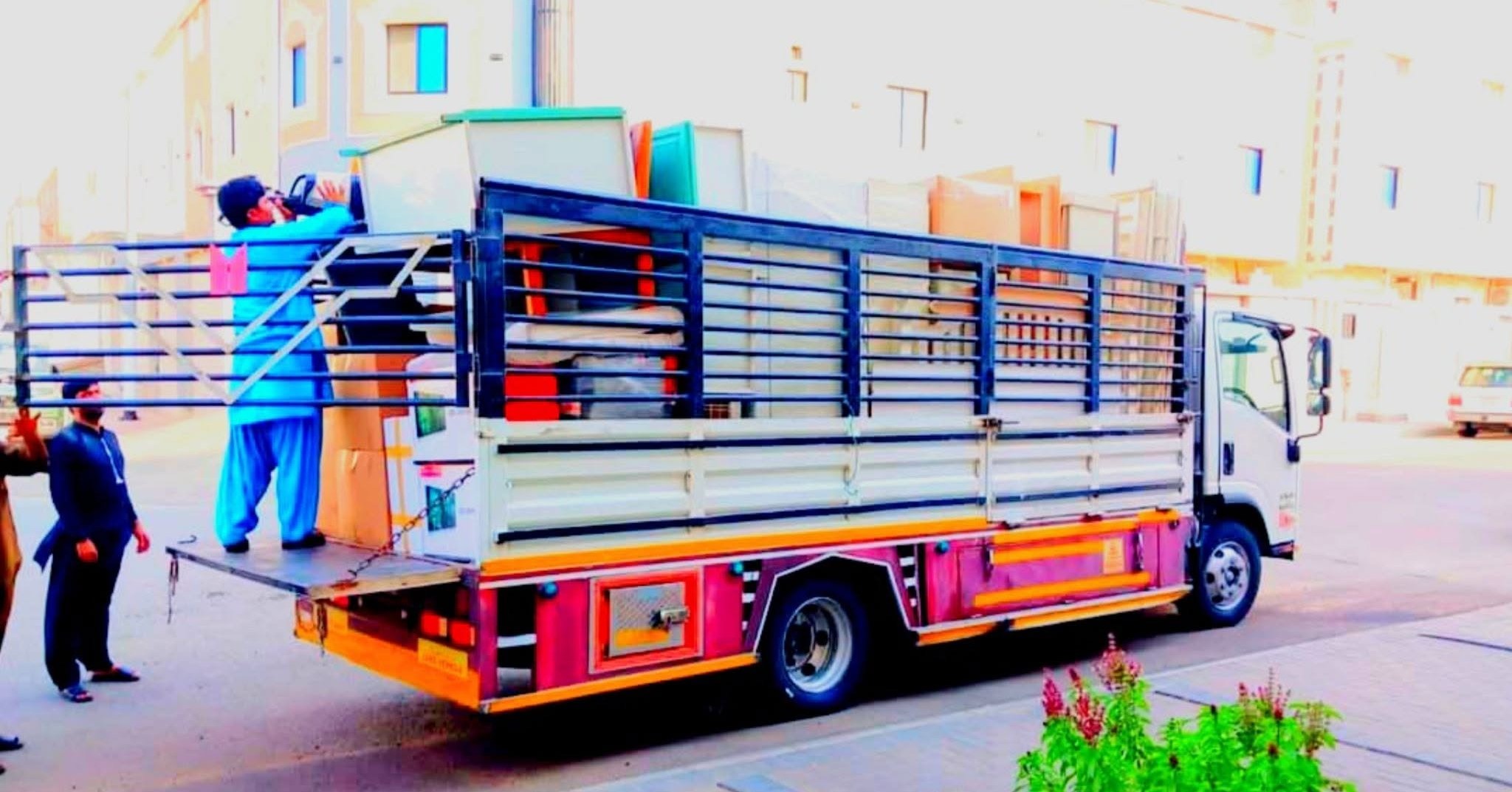 Movers and packers loading furniture onto a truck in Jeddah